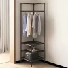 A minimalistic tubular corner shelf and clothes rack in black with five shirts hanging