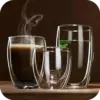 Double walled drinking glasses with steamin coffee and another with water and mint leaf