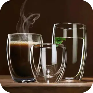 Double walled drinking glasses with steamin coffee and another with water and mint leaf