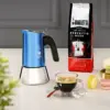 Bialetti Venus Blue Moka Pot paired with a cup off coffee, macaroons and a bag of ground coffee.