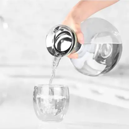 Pouring water into a glass from Clear Glass Pitcher With Handle