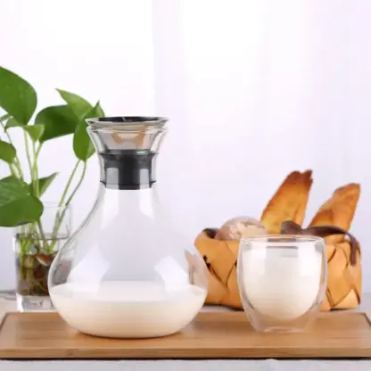Clear Glass Pitcher With Handle on tray filled with milk and glass of milk next to it