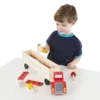 Child playing with Melissa & Doug Big Rig Building Truck Wooden Play Set on table