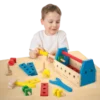 A child palaying with a Melissa & Doug take-along tool kit wooden construction toy