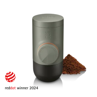 Minipresso GR2 Coffee Maker with a small mount of coffee grinds and reddot logo with the text "reddot winner 2024