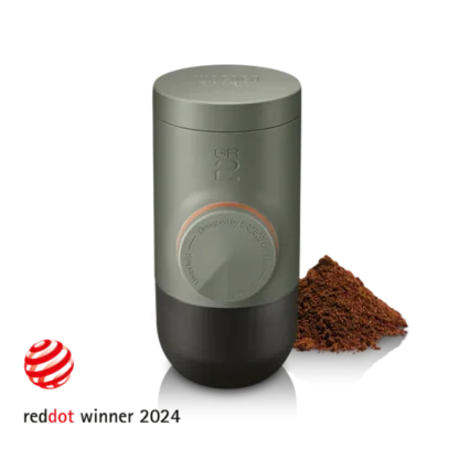 Minipresso GR2 Coffee Maker with a small mount of coffee grinds and reddot logo with the text "reddot winner 2024
