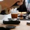 Picopresso Portable Espresso Machine in an indoors setting with a espresso glass on a scale