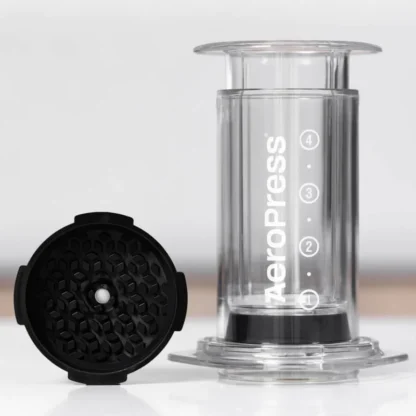 AeroPress flow control filter cap next to AeroPress clear