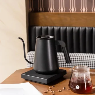 Gooseneck Pour-Over Kettle With Precision Temperature Control on table with a jug of coffee and coffee beans on table