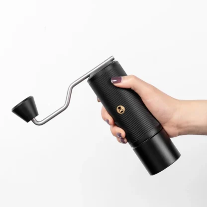 Chestnut X-lite Manual Portable Coffee Grinder held in a lady's hand showing the compactness of the design