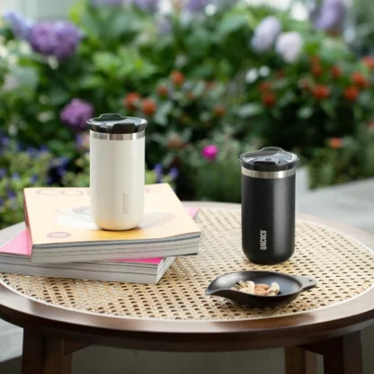 Wacaco Vacuum Insulated Travel Mug In Black And White Lungo 300ml Coffee Cup On A side Table